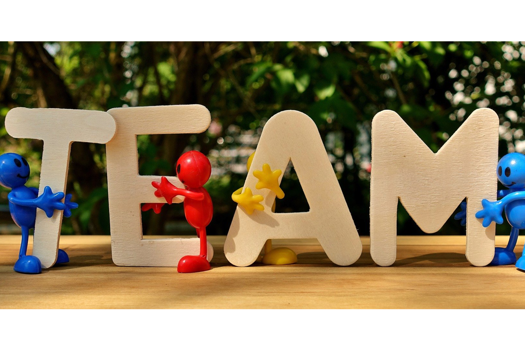 Foto: Schriftzug "TEAM" aus Holzbuchstaben, gehalten von bunten Plastikmännchen, Bildnachweis: Alexas_Fotos auf pixabay, https://pixabay.com/de/photos/team-teamwork-gemeinsam-strategie-3393037/